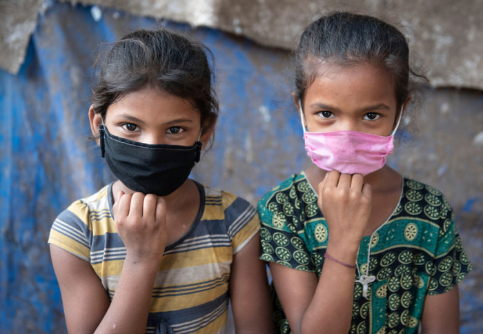 Two young girls wearing facemasks