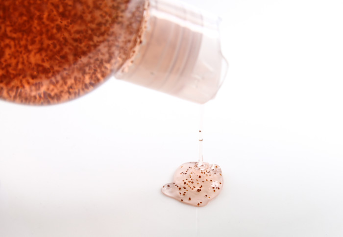 Bottle spilling a microbead scrub