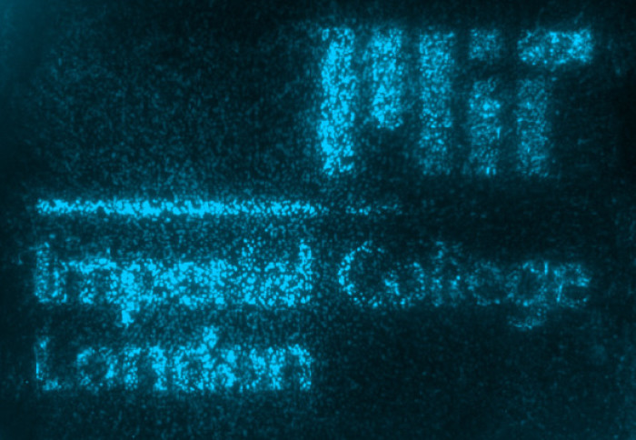 Imperial College London and MIT logos glowing in blue fluorescence caused by the engineered living materials (ELMs)