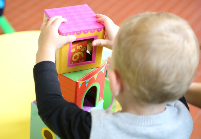 Toddler playing with building blocks in a nursery