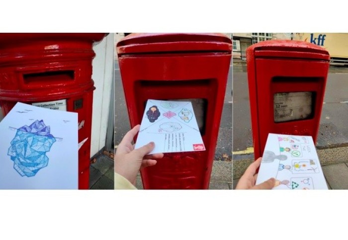 Postcards being put into red pillar boxes