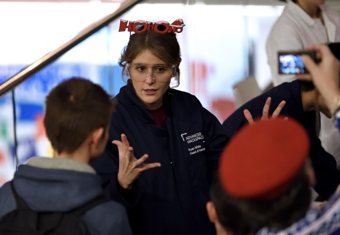 Woman gives practical science presentation to young people