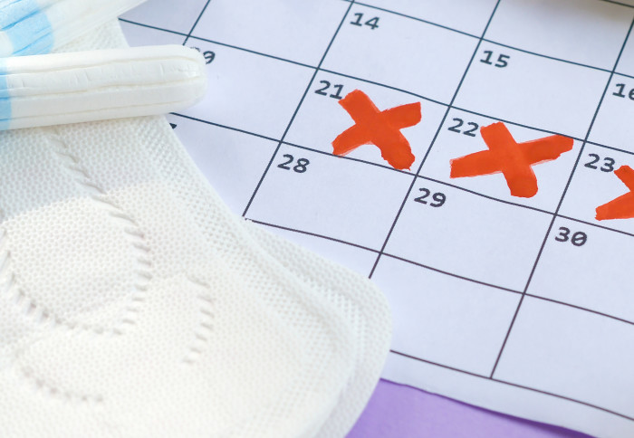 Menstrual pads and tampons on menstruation period calendar
