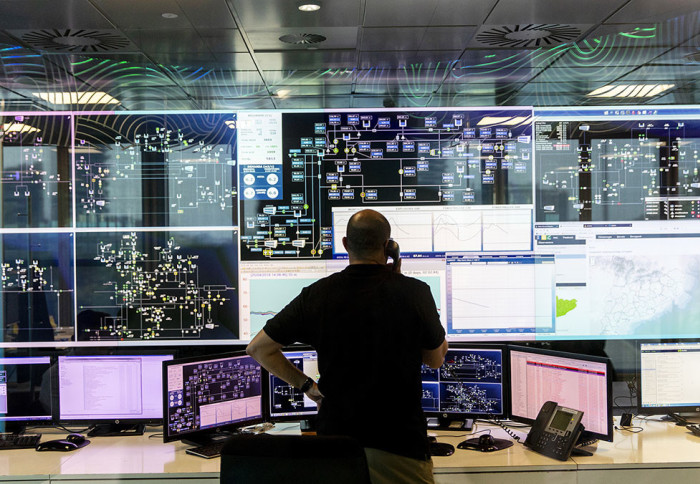 A man standing in front of a large array of digital displays