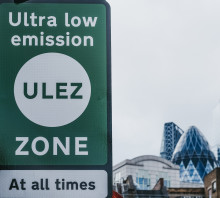 Photo of ULEZ sign in foreground, Gherkin building in background