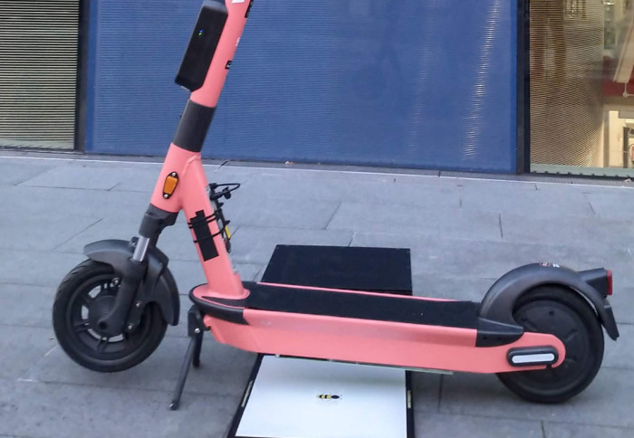 Bumblebee Power's wireless charging pad shown providing charge to an e-scooter