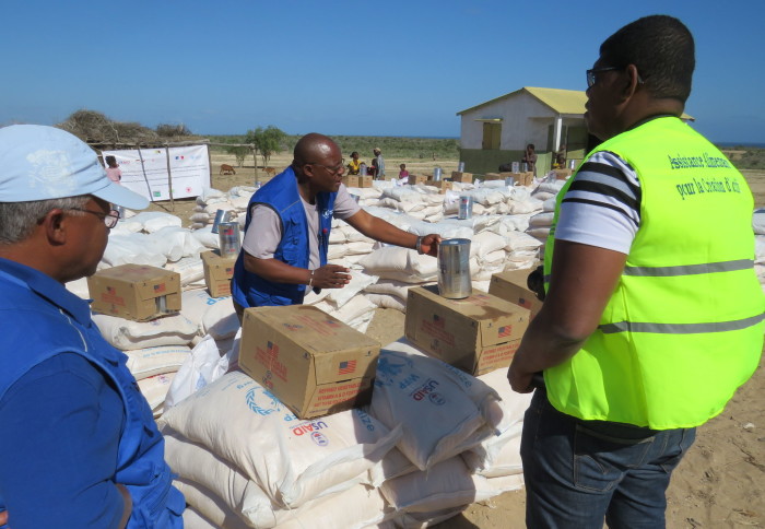 Three officals (all men) standing in a food distribution centre in response to famine in southern Madagascar.