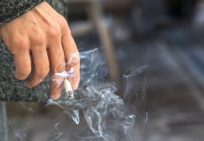 A person smokes a cigarette outside