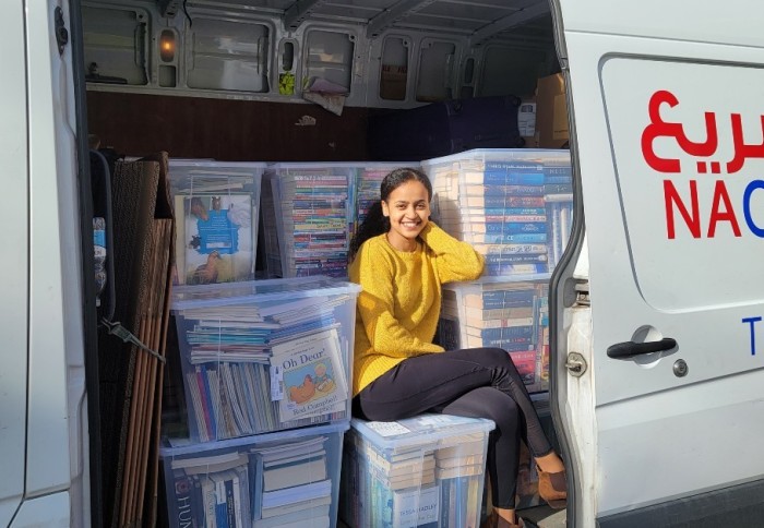 Bethlehem Solomon, from Imperial’s School of Public Health, sits with some of the books she collected