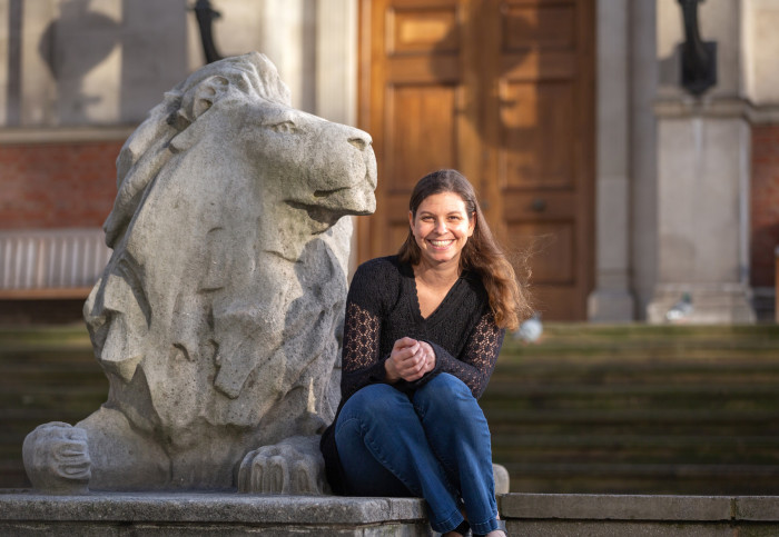 Professor de Rham sitting next to a stone lion
