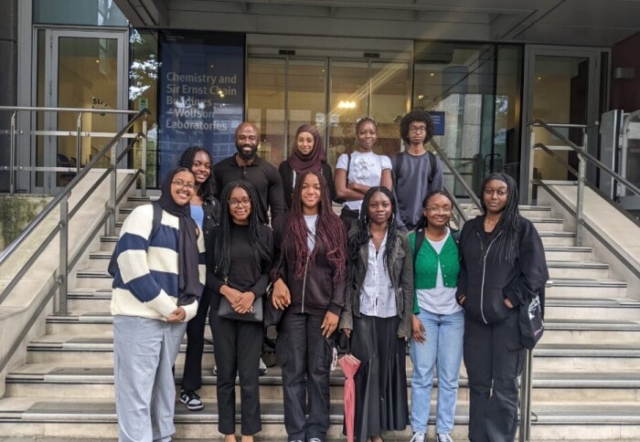 This year's cohort of students in the summer placement scheme. They are pictured with their mentors, smiling, in front of the Chemistry Building.