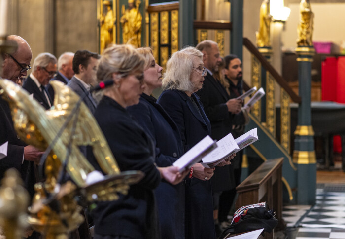 People standing in Holy Trinity Church, singing hymns.