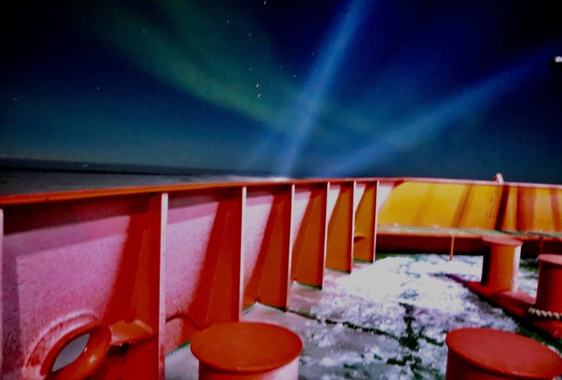Hull of a boat, showing northern lights in the distance
