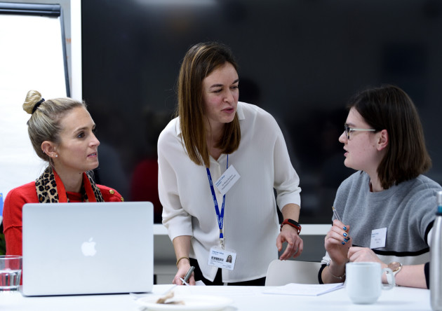 three attendees converse at an event run by The Forum