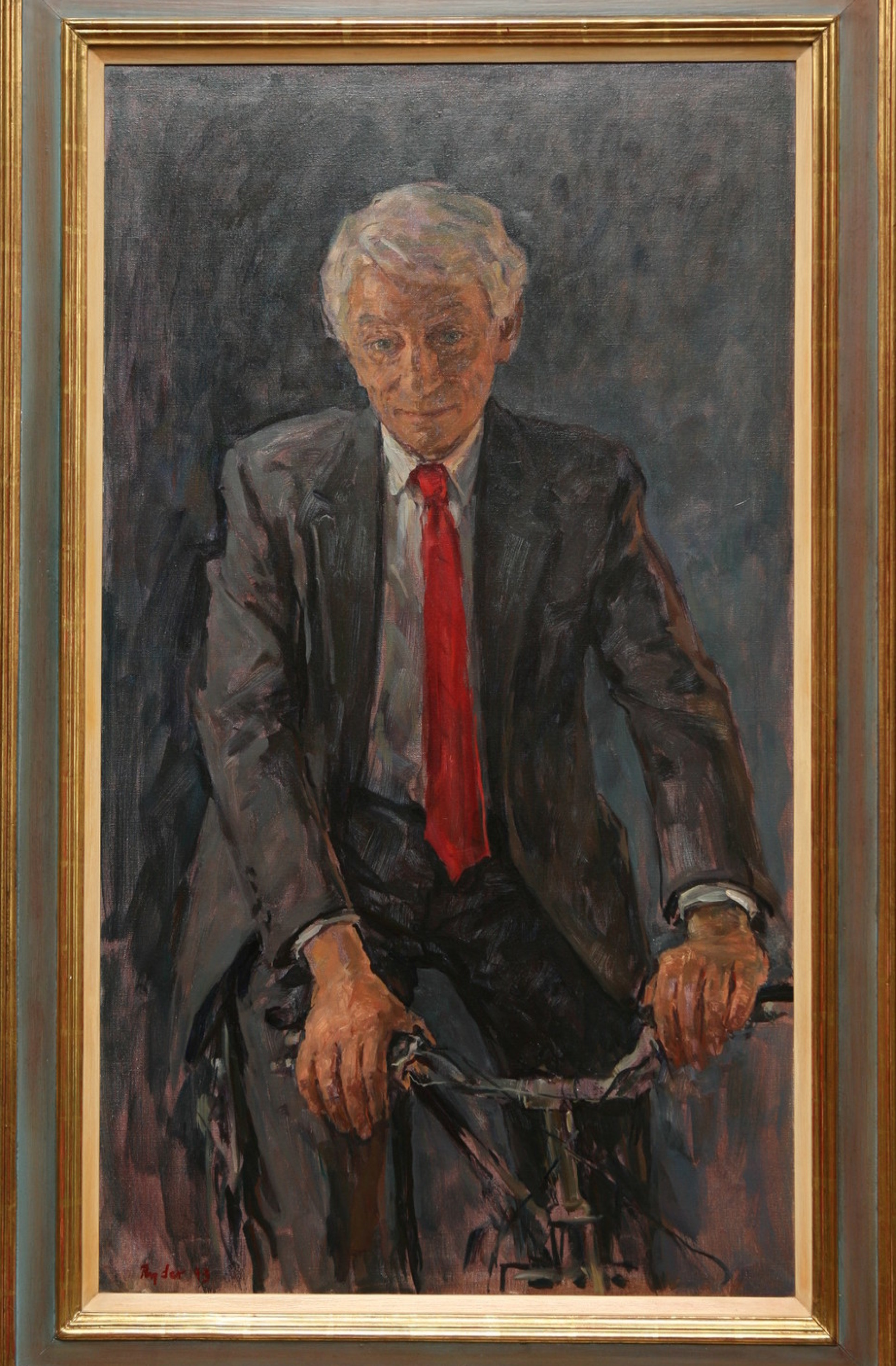 Elderly white man in suit and tie rides bicycle