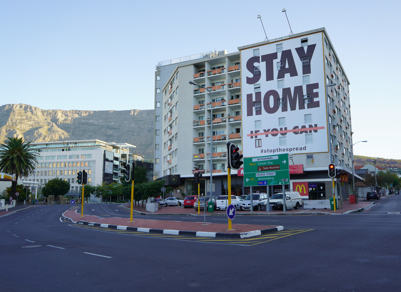 Pictire of a building with a huge 'stay at home' sign