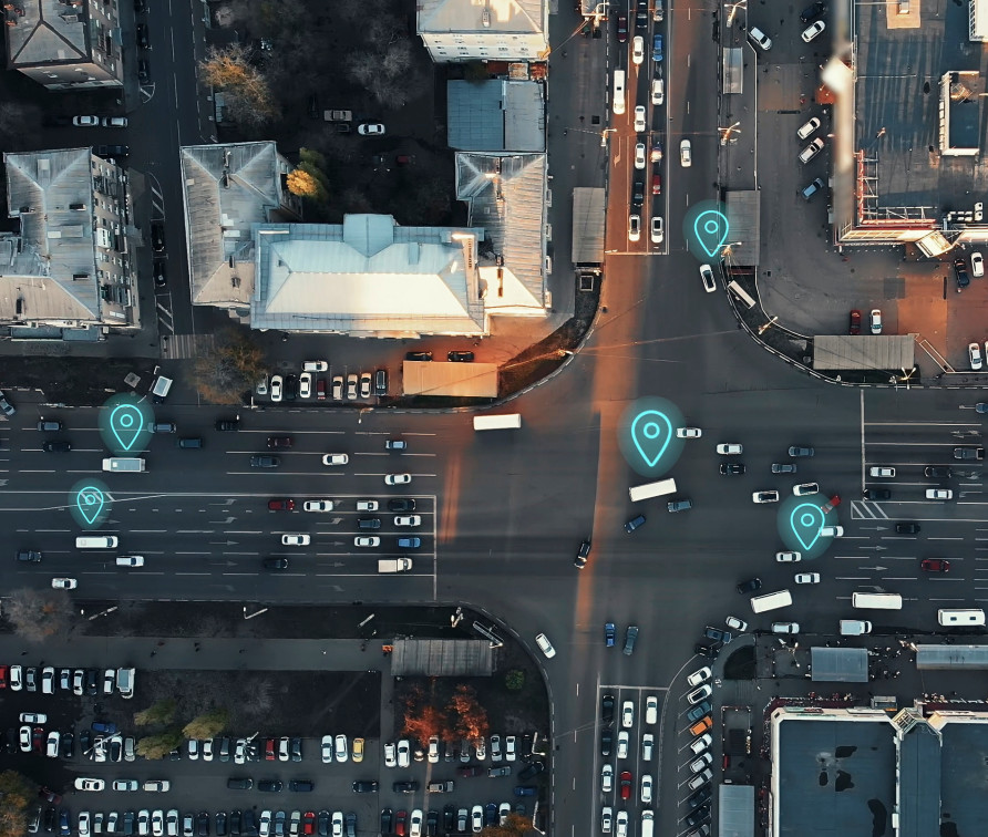 Aerial view of a crossroad with cars marked by symbols typically seen on GPS GPUs.