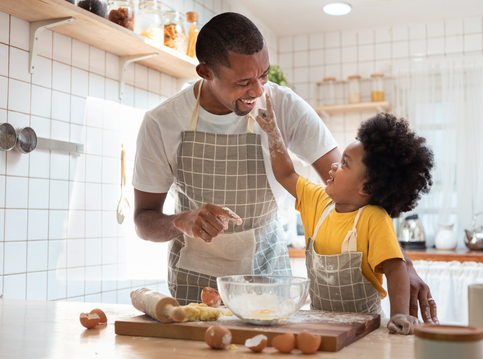 Black man and young boy baking in a kitchen