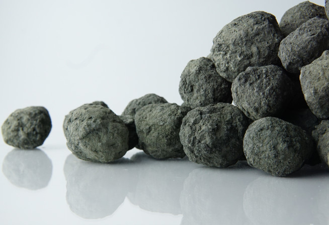 Balls of grey cement clinker on white background