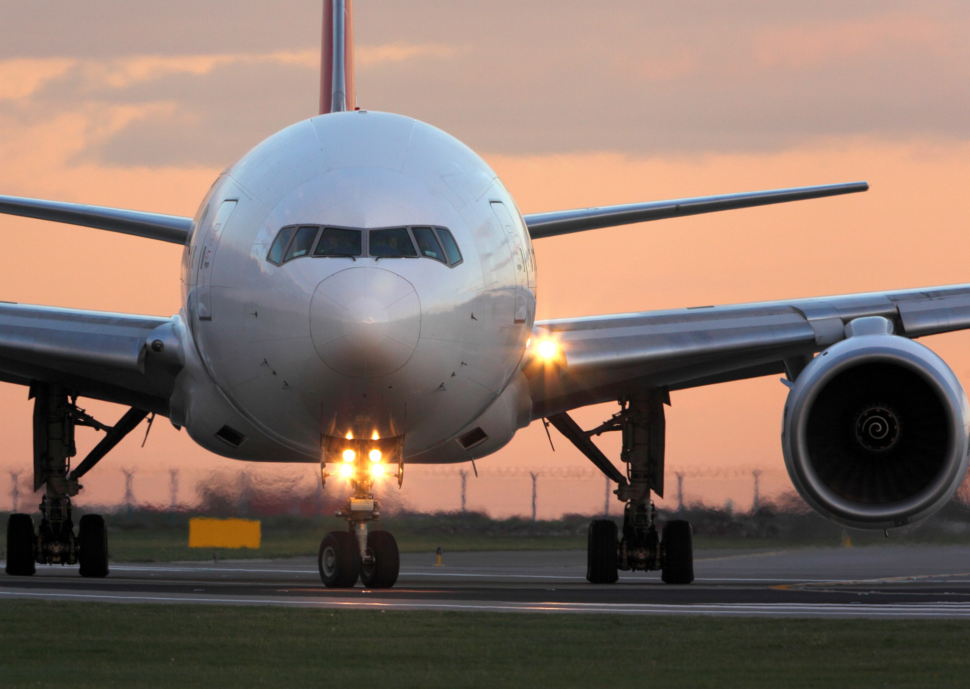 Passanger jet on runway at sunset