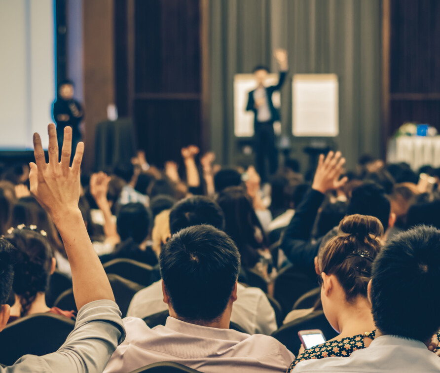 A crowd watching a speaker present