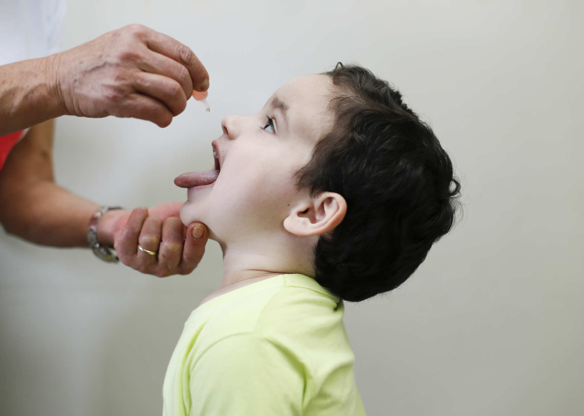 A young boy receiving an oral polio vaccine