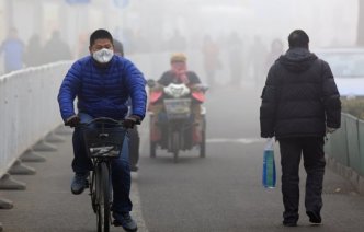 A man cycling in polluted conditions
