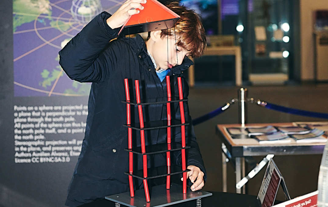 A visitor re-stacks the fallen string house