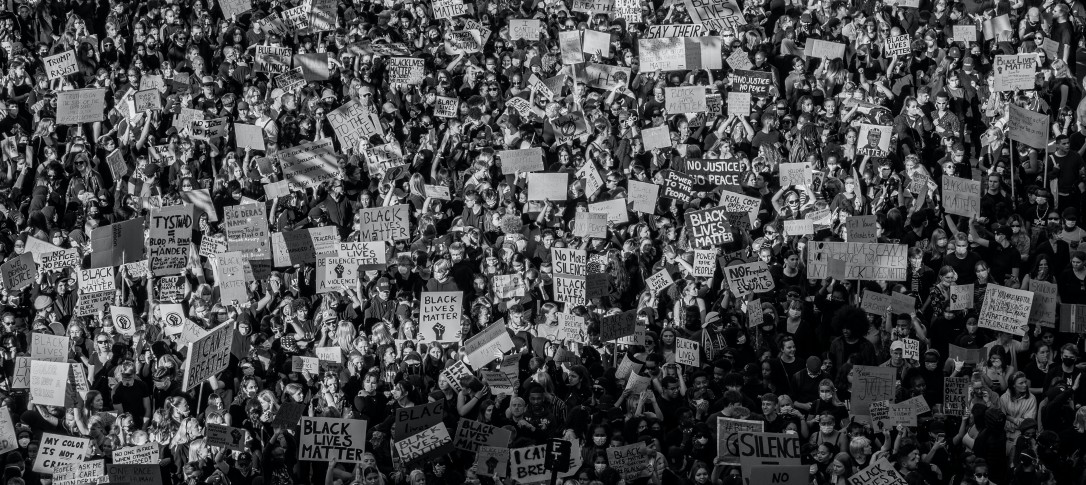 A black and white aerial image of a crowdof people, some with placards,  during a Black Lives Matter protest. 