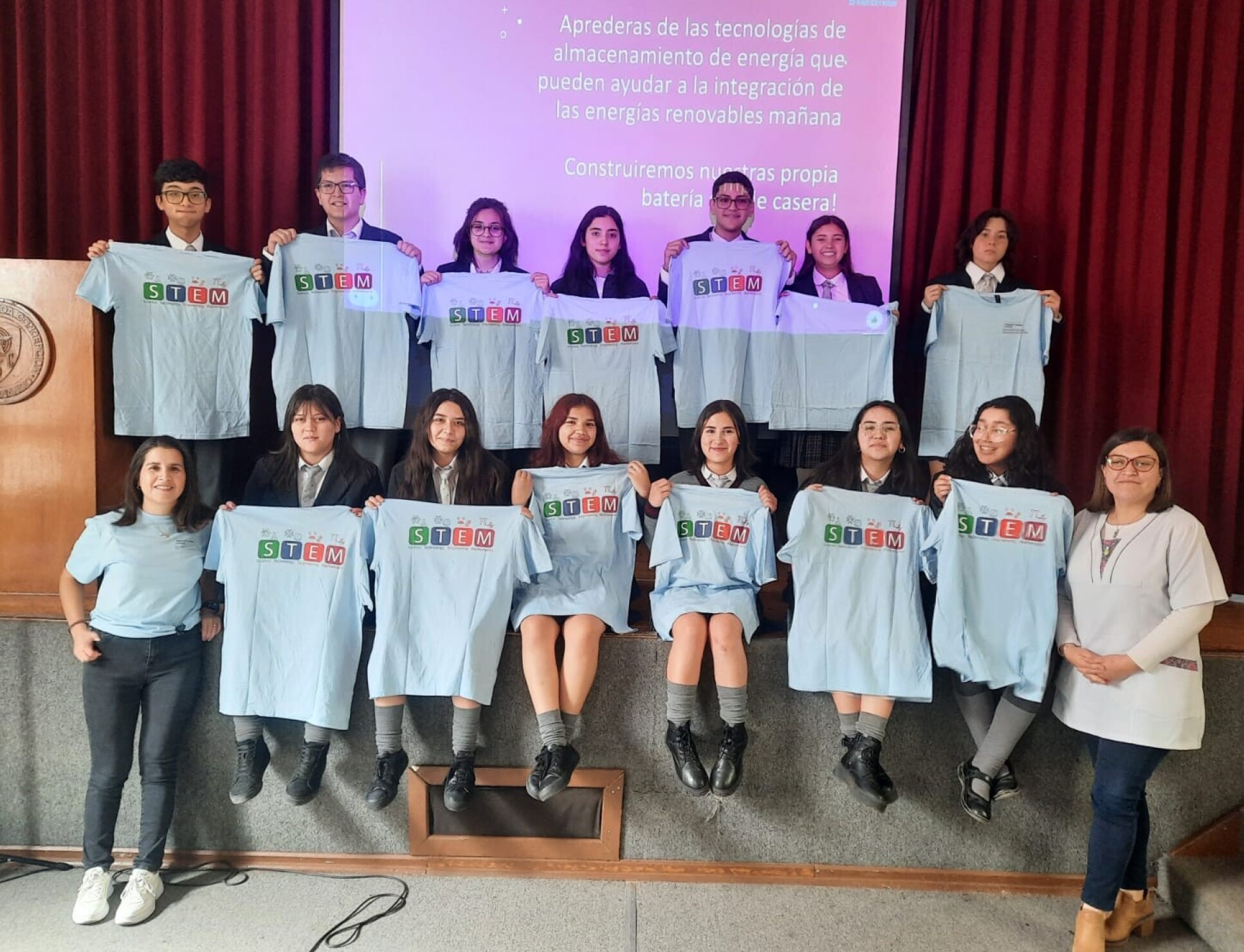 Catalina and the students smile, holding 'Women in STEM' t-shirts