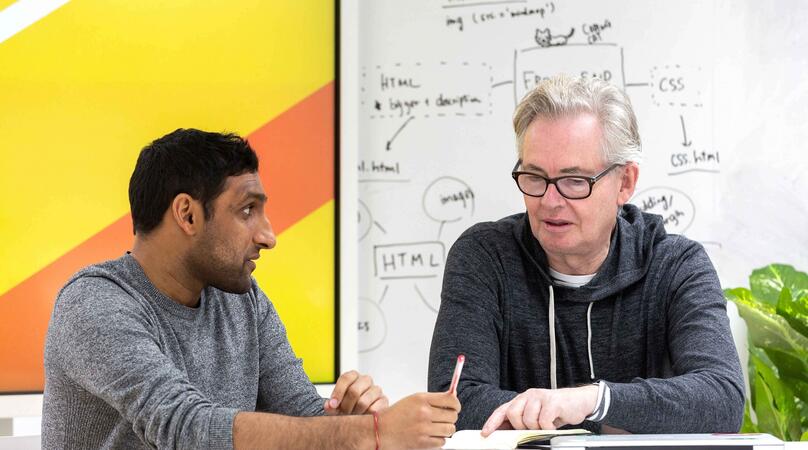 An Executive MBA student and tutor in a classroom discussing a topic