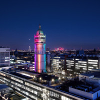 Photo of Queens Tower at night, lit in rainbow colours