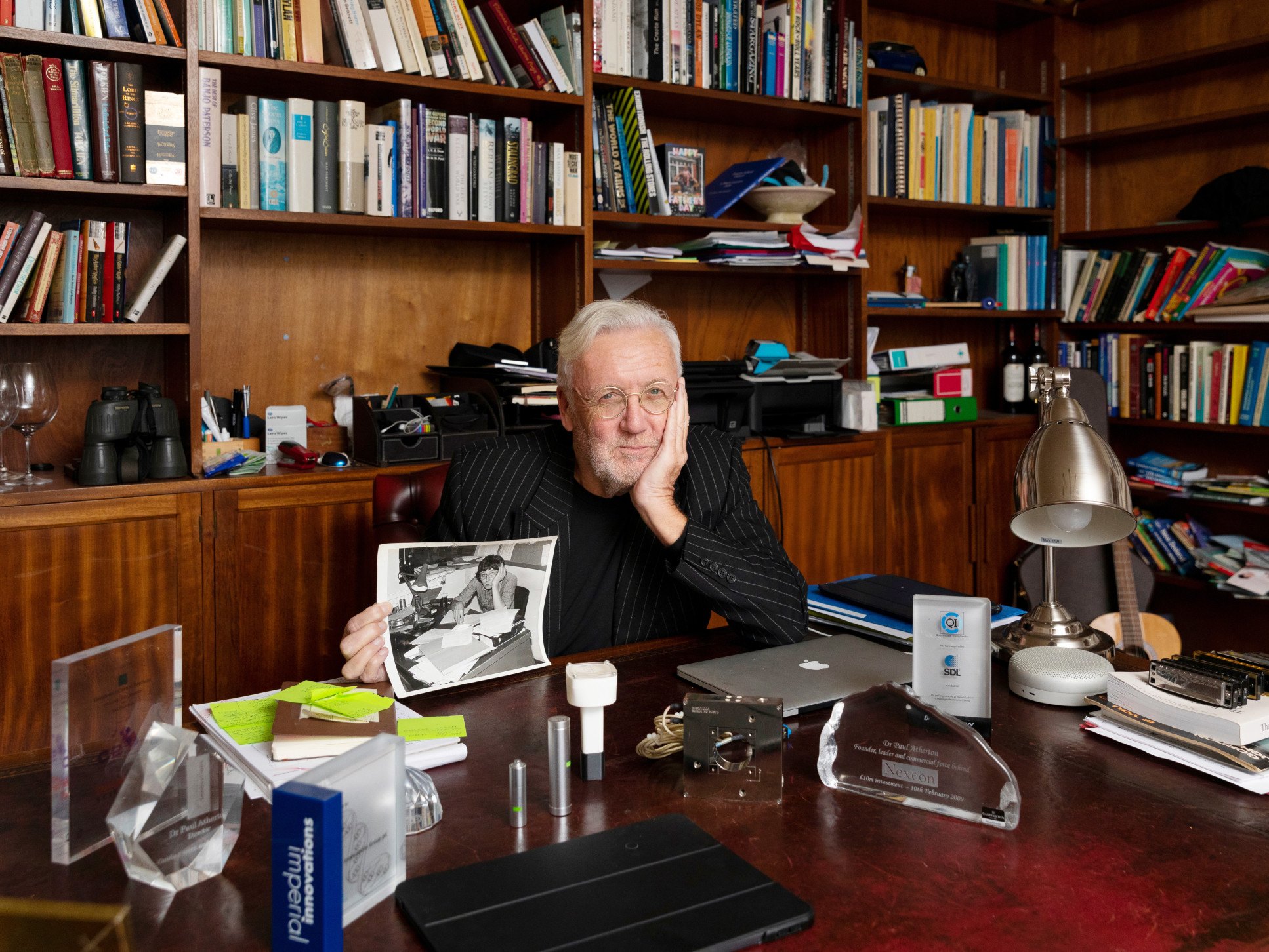 Paul Atherton sitting at a desk surrounded by books