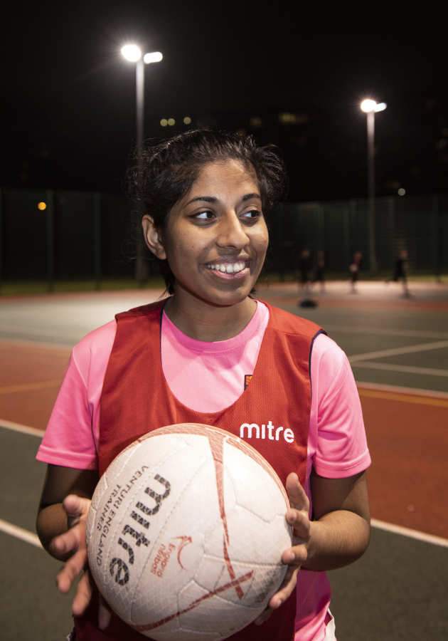 Undergraduate student Aishwarya Chidambaram holdiing a netball on court