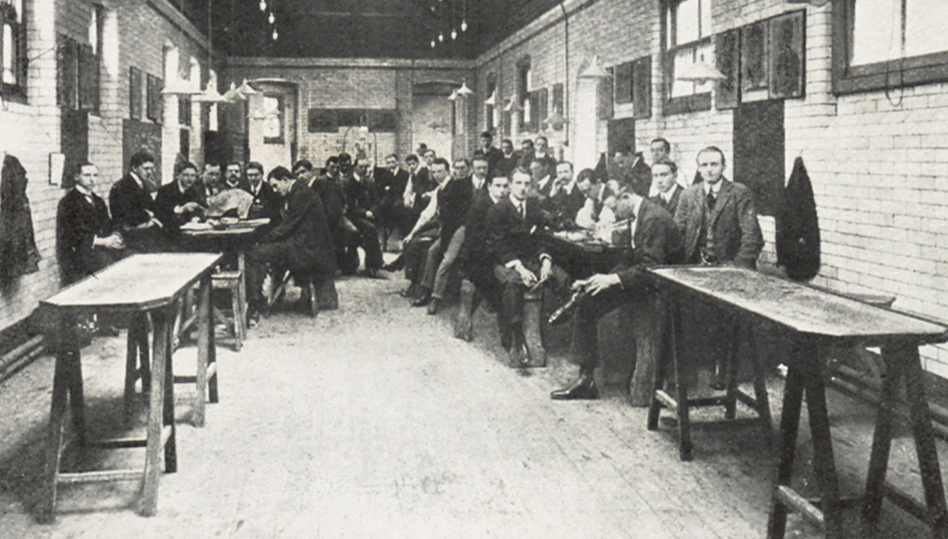 A black and white image of students sitting in a dissecting room in the early 1900s.