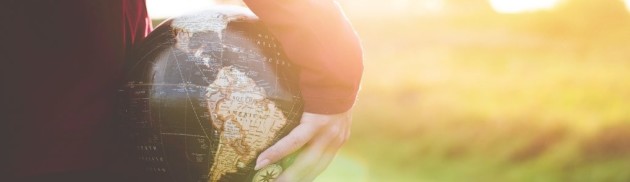 Person holds globe under their arm