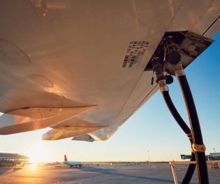 Refueling of the airplane, sunset background