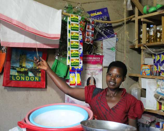 African woman in a shop in Rwanda clicking a power switch