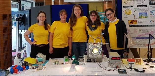 5 female students and postdocs at solar energy stand at science festival