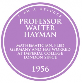 round purple plaque with the words 'I am a refugee - Professor Walter Hayman - Mathematician, fled Germany and has worked at Imperial College London since 1956' 