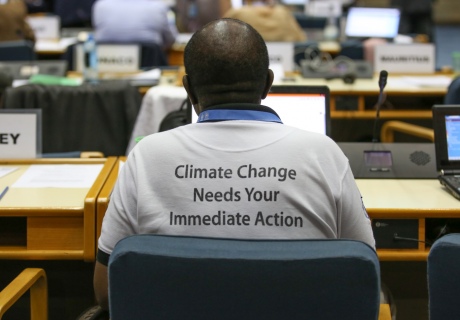 Back of a man's shirt, reading: climate change needs your immediate action