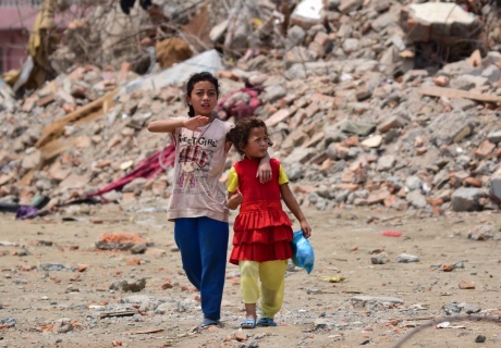 Nepal earthquake 2015 with children walking through the rubble