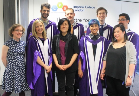 PhD graduands in purple gowns, with staff members