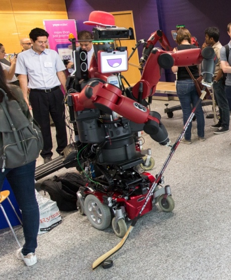 Robot DE NIRO, a large red robot, standing with a hockey stick
