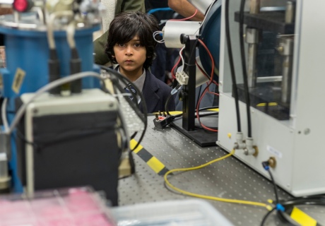 Boy peeks out between lab equipment