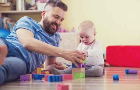 A young father plays with his baby