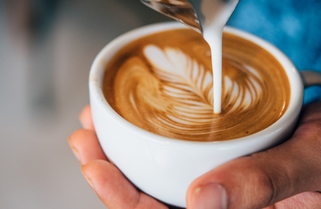 A strong latte being poured into a cup