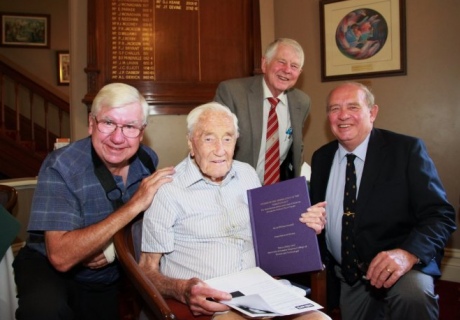 Professor David Goodall with colleagues, holding his specially bound PhD thesis. 