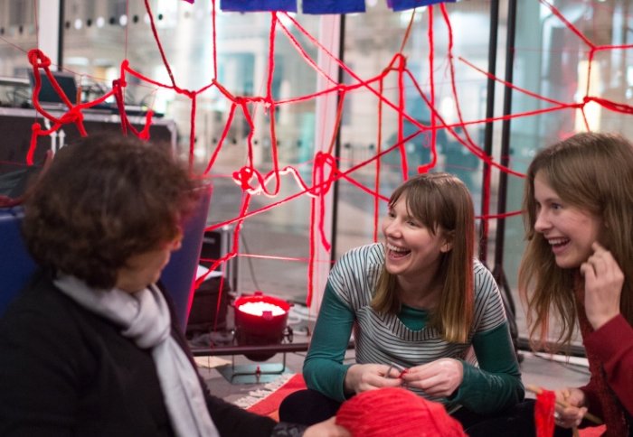 Public and scientists discussing research while knitting blood vessels