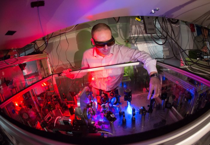 Man adjusting lenses in a laser setup